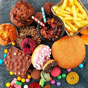 ansiedad por comer Variedad de alimentos ultraprocesados como hamburguesas, papas fritas, dulces y refrescos que pueden causar adicción a la comida.