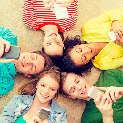 Grupo de adolescentes compartiendo de forma positiva con sus celulares, demostrando una sana autoestima y amor propio en sus relaciones digitales.
