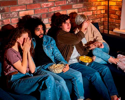 Jóvenes experimentando los efectos del miedo mientras ven una película de terror