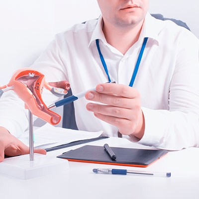 Un ginécologo explicando como el VPH causa cáncer de cuello uterino