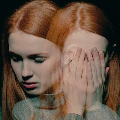 Imagen conceptual de la paramnesia reduplicativa que muestra a una mujer pelirroja duplicada mediante un efecto de doble exposición, simbolizando la creencia delirante de que un lugar o persona existe en dos sitios a la vez.