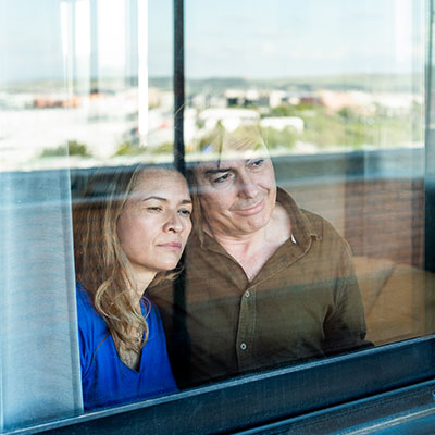 una pareja madura que se ve triste por la ventana
