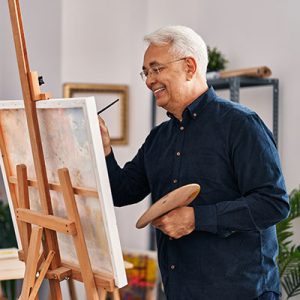 hombre mayor dibujando en estudio de arte