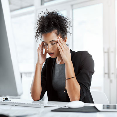 mujer sentada en su oficina cansada con mala salud mental en el trabajo