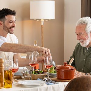adulto mayor cenando con su hijo