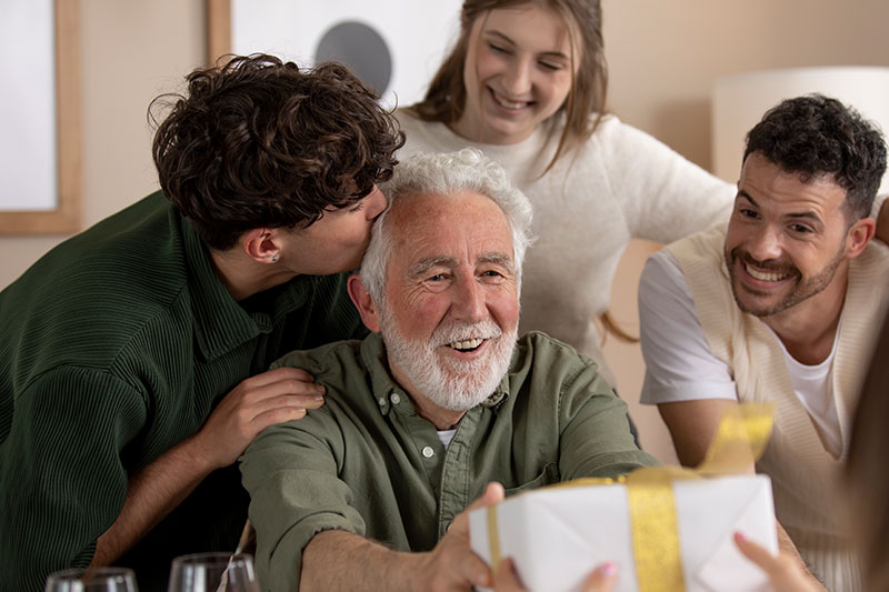 adulto mayor en compañia de familiares