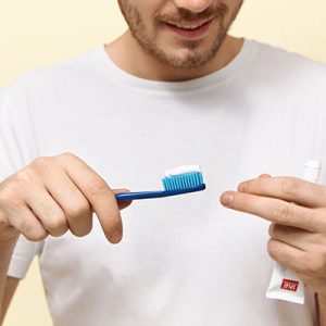 hombre cepillando los dientes