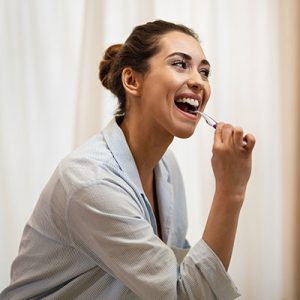 mujer cepillando dientes
