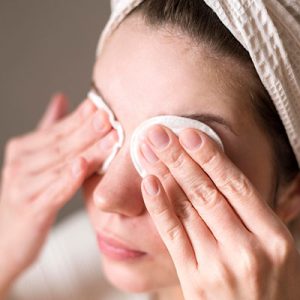 mujer utilizando compresas en los ojos