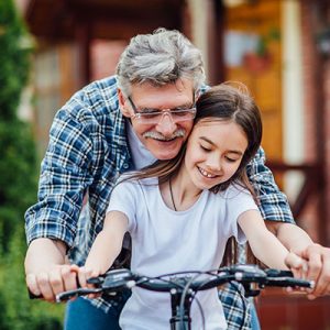 abuelo enseña a montar cicla a su nieta