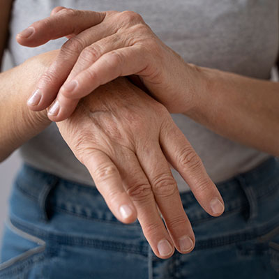 manos de una persona adulta mayor, representando la fragilidad ósea y la importancia del diagnóstico de la osteoporosis.