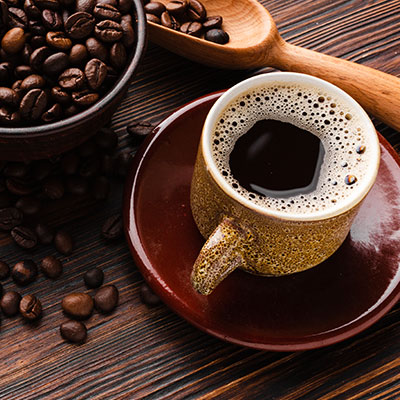 Taza de café sobre una mesa de madera que ilustra el consumo equilibrado y los efectos de la cafeína en la salud.