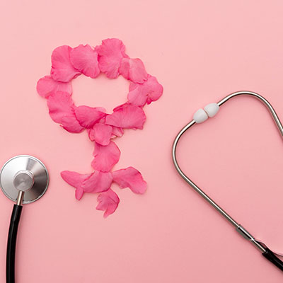 Consejos para prevenir la vaginosis bacteriana: Símbolo femenino formado por pétalos junto a un estetoscopio sobre fondo rosa, representando el cuidado de la salud íntima.