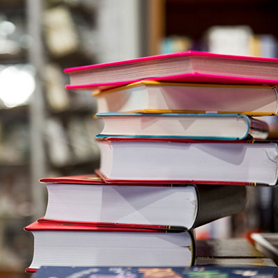 Pila de libros coloridos en una biblioteca, representando la diversidad literaria de India en la FilBo 2026.