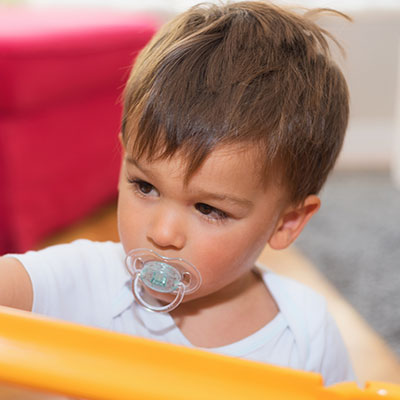 Niño pequeño con chupete recibiendo cuidados preventivos, clave para mantener una buena salud oral en niños y evitar maloclusiones.