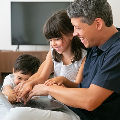 Padre acompañando las etapas de exploración en los niños mediante el uso supervisado de herramientas digitales en casa.