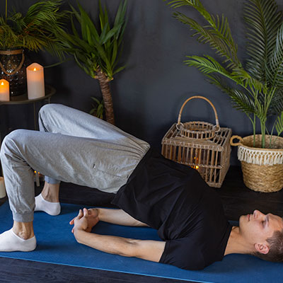 Hombre realizando técnica de elevación de pelvis para fortalecer el suelo pélvico masculino mediante ejercicios de Kegel.