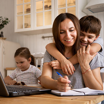 Madre brindando apoyo emocional y acompañamiento a sus hijos durante la escolaridad remota en casa.