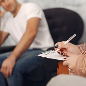 Hombre-conversando-con-un-psicólogo-en-una-sesión-de-terapia